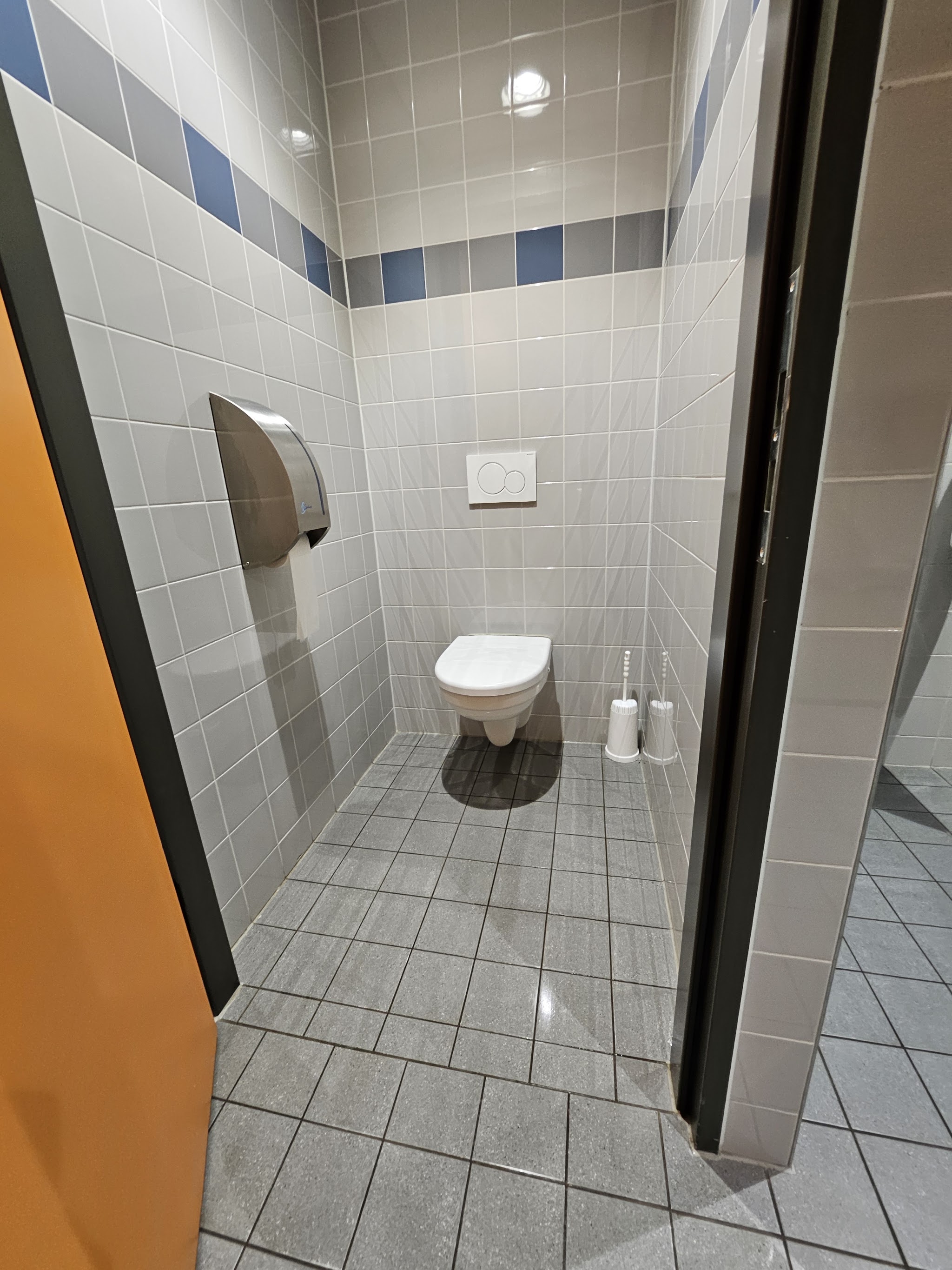 Schoon toilet met betegelde wanden en een glanzende tegelvloer